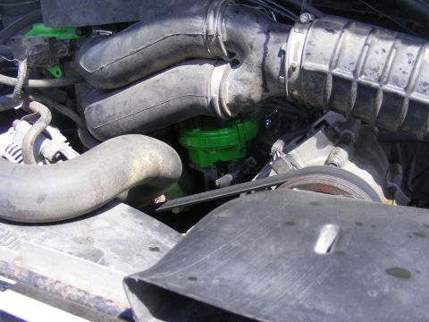1996 Ford Bronco - A close-up view of engine components, including hoses and a green-colored filter.