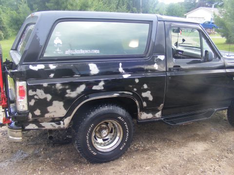 1996 Ford Bronco - This black Ford Bronco shows significant paint damage and wear.