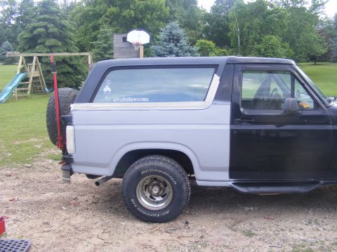 1996 Ford Bronco - This Ford Bronco shows a two-tone paint scheme with a primer gray rear quarter panel and a black front half, an external spare tire.
