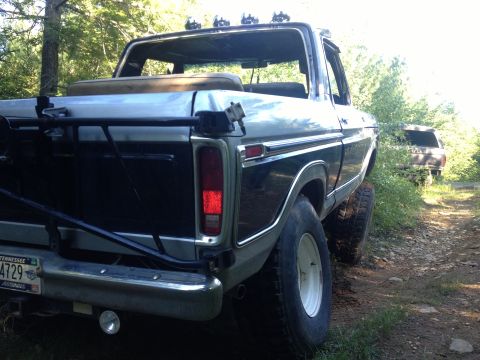 1979 Ford Bronco - Rear view of a 1978 Ford Bronco on a dirt road, with another vehicle visible in the distance.