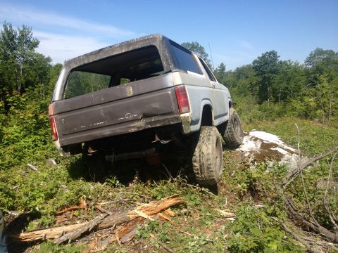 1979 Ford Bronco - A modified Ford Bronco navigates a challenging off-road terrain.