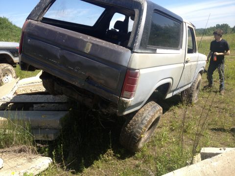 1979 Ford Bronco - A 1978 Ford Bronco is precariously balanced on concrete blocks, with another vehicle visible in the background.