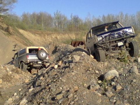 1979 Ford Bronco - Two Ford Broncos tackle a challenging off-road course on a sunny day.