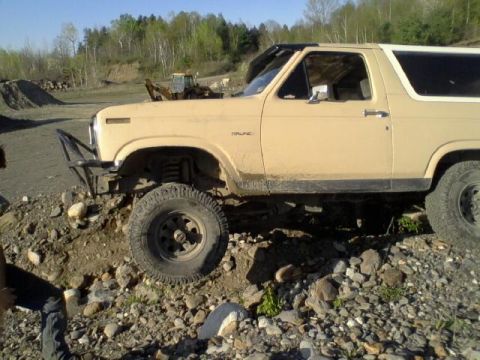 1979 Ford Bronco - A tan 1978 Ford Bronco is shown from the side on a rocky, off-road course.