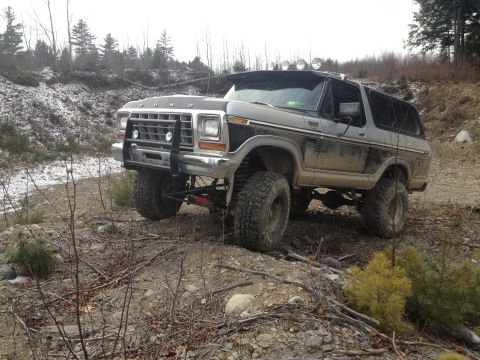 1979 Ford Bronco - This lifted Ford Bronco is navigating a rough, wooded terrain.