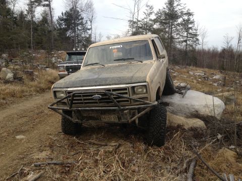 1979 Ford Bronco - Ford Bronco navigating rough terrain with another truck in the background.