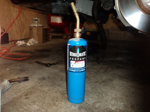 2004 Mercury Grand Marquis - A Bernzomatic propane torch and tank are shown, with car parts visible in the background.