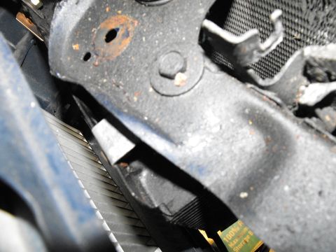 1986 Chrysler Fifth Avenue - Here's the driver's side top corner of the cooler being supported by a 90 degree bracket "nutted" to a bolt that holds on the hood latch.