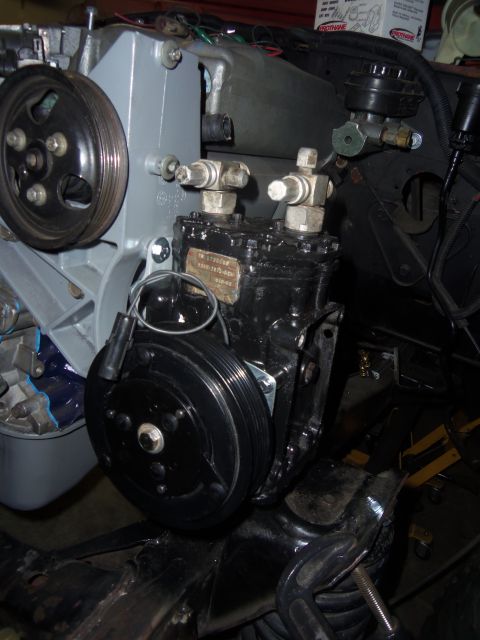 1968 Ford Bronco - Close-up view of an engine component, likely an AC compressor, with associated pulleys and hoses.