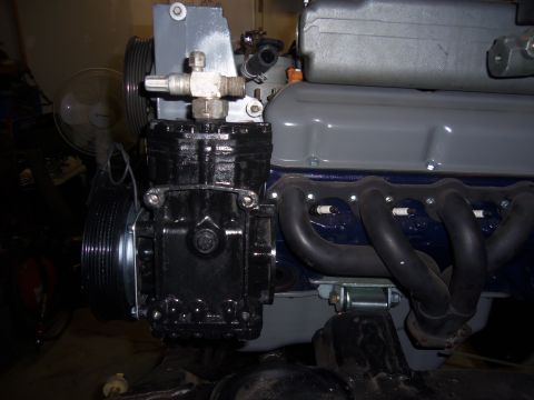 1968 Ford Bronco - Engine component assembly showing a compressor, exhaust manifold, and pulleys.