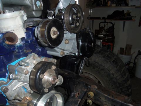1968 Ford Bronco - A close-up view of engine parts and a large tire, possibly during a restoration or repair project.