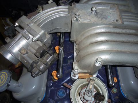 1968 Ford Bronco - Close-up view of an engine's intake manifold, throttle body, and fuel injectors.