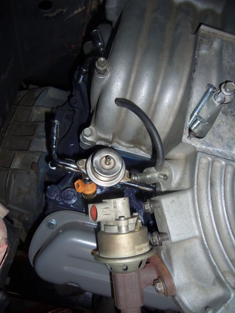 1968 Ford Bronco - Close-up of engine fuel pressure regulator and intake manifold assembly.
