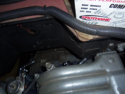 1968 Ford Bronco - Close-up view of engine components, including the intake manifold and fuel filter, with visible plumbing and tubing.