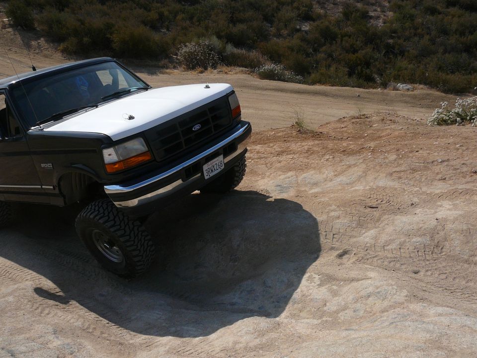 Black and white 1992 Ford Bronco front 3/4 view on dirt road