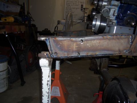 1968 Ford Bronco - Frame section being worked on, with engine components in the background.