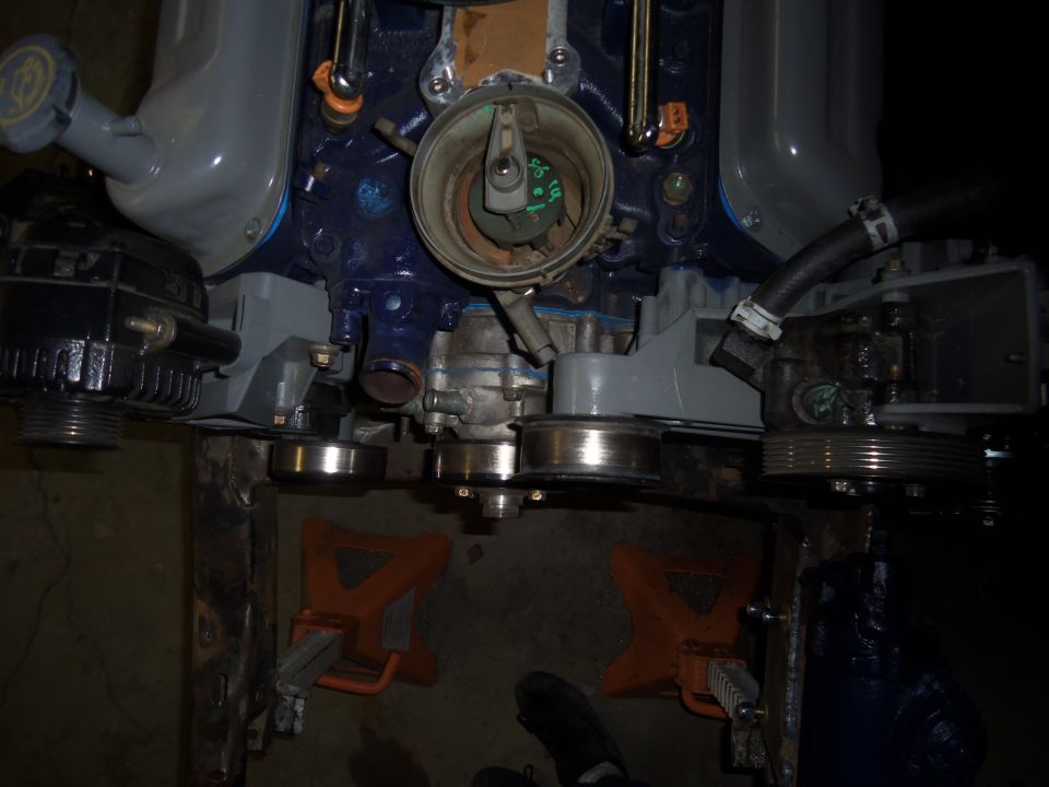 Blue engine block with grey intake manifold, black alternator, and open distributor cap