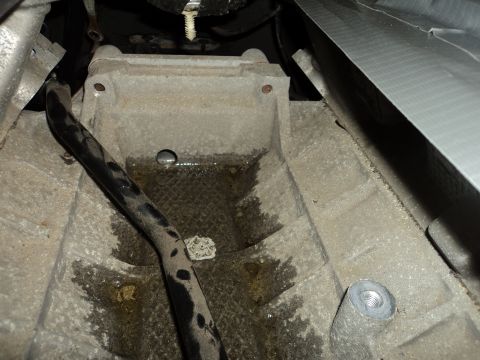 2004 Mercury Grand Marquis - Underside view of a vehicle's mechanical component, showing oil residue and a black hose.