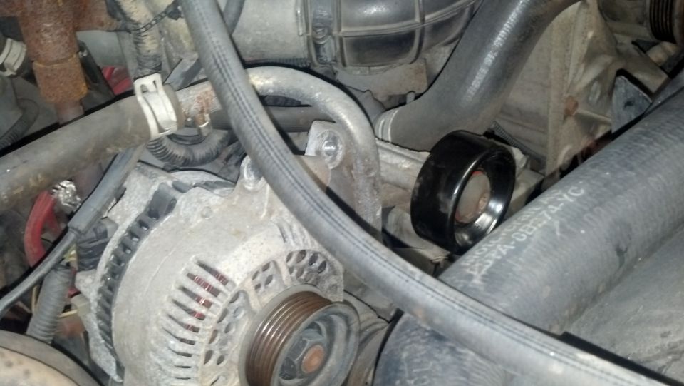 Black belt tensioner pulley on engine