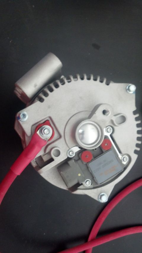 1995 Ford Bronco - Close-up of an automotive alternator, showing its internal components and wiring connections.
