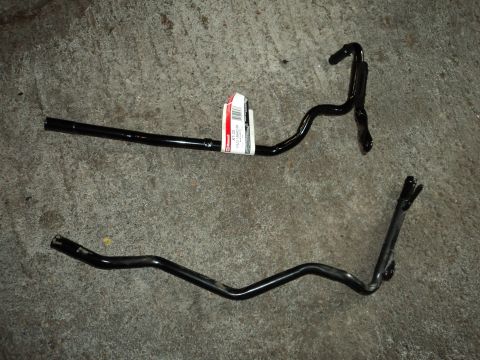 2004 Mercury Grand Marquis - Two black metal automotive parts are shown on a concrete surface, one with a Ford label.