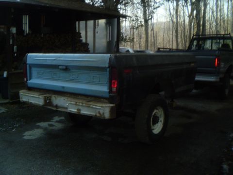 1979 Ford Bronco - The rear of a Ford pickup truck is shown, with another truck visible in the background.