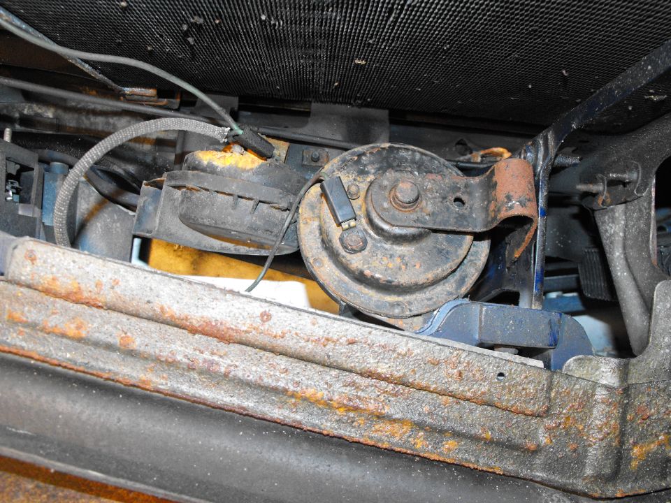 This pic was shot upside down from under the bumper. By relocating the passenger's side horn over to the driver's side of the center core support, you make enough room for the huge stacked plate transmission cooler (there it is in the right side of the pic, just on the other side of the center core support. Again I utilized existing bolts to secure the horn in it's new home. No wires were cut either.