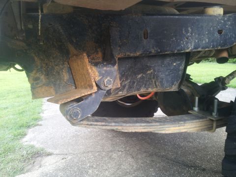 1988 Ford Bronco - Close-up of the undercarriage reveals the vehicle's frame, suspension components, and leaf springs.