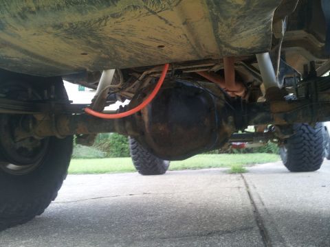 1988 Ford Bronco - The underside of a vehicle is visible, with focus on the rear axle and suspension components.