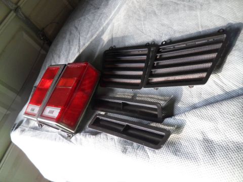 1994 Jeep Cherokee - 1994 Jeep Cherokee tail lights and grille inserts are laid out on a tarp.