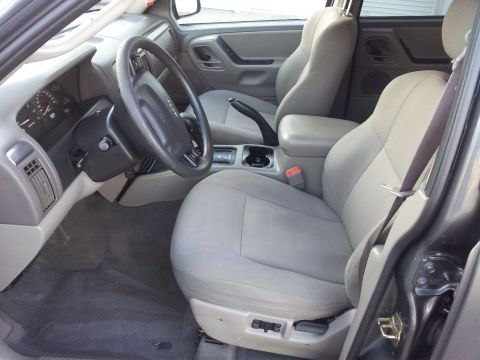 2002 Jeep Grand Cherokee - The interior of a 2002 Jeep Grand Cherokee is visible, including the front seats and dashboard.