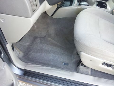 2002 Jeep Grand Cherokee - Passenger side interior of a 2002 Jeep Grand Cherokee, the floor mat and seat base.