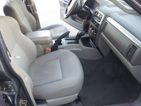 2002 Jeep Grand Cherokee - The interior of a Jeep Grand Cherokee is shown, cloth seats and the center console area.