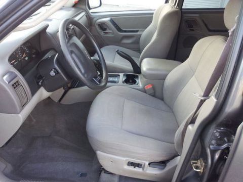 2002 Jeep Grand Cherokee - The interior of a 2002 Jeep Grand Cherokee features cloth seats, a dashboard with visible gauges, and a steering wheel.