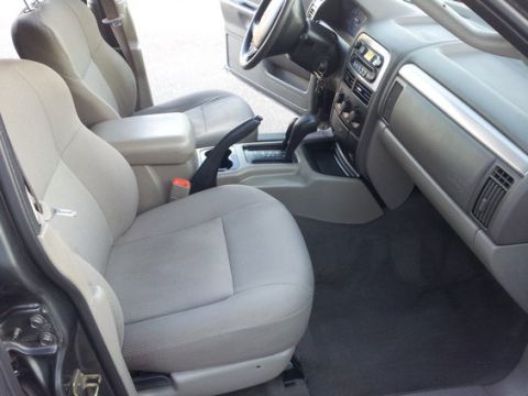 2002 Jeep Grand Cherokee - The interior of a 2002 Jeep Grand Cherokee is visible, light gray cloth seats and the dashboard.