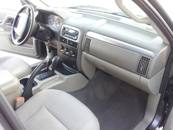 Interior of a 2002 Jeep Grand Cherokee showing dashboard, steering wheel, and seats