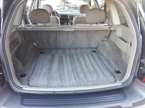 2002 Jeep Grand Cherokee - The interior of a car trunk shows a gray carpeted floor and cargo cover, with visible water stains.