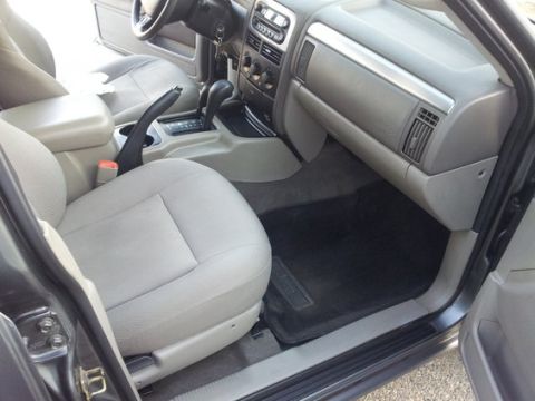 2002 Jeep Grand Cherokee - The interior of a 2002 Jeep Grand Cherokee shows light gray seats and a dark gray dashboard.