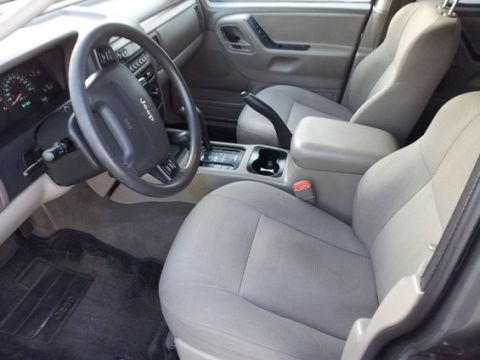 2002 Jeep Grand Cherokee - The interior of a 2002 Jeep Grand Cherokee, its dashboard, steering wheel, and front seats.