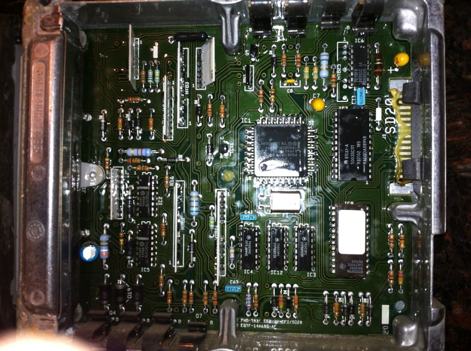 Close-up of an electronic control module circuit board with various components and traces