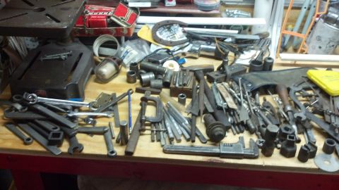 2004 Aston Martin Virage - A workbench is covered in a variety of tools, suggesting a workshop or repair area.