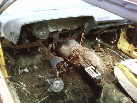 1974 Dodge Challenger - Interior view of a 1974 Dodge Challenger, showing significant wear and damage to the dashboard and interior components.