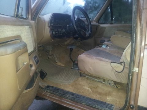 1988 Ford Bronco - The interior of a 1988 Ford Bronco, its dashboard, steering wheel, and tan seats.