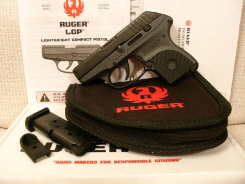 2003 Ford Crown Victoria - Ruger LCP pistol, magazine, and instruction manual are laid out on a box.