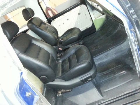 1967 Ford F-100 - The interior of a vehicle is shown with black leather seats and unfinished door panels.
