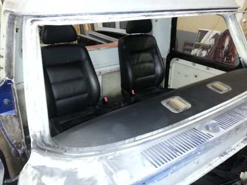 1967 Ford F-100 - Black leather bucket seats are installed in the interior of a pickup truck, which appears to be undergoing restoration.