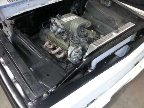 1967 Ford F-100 - Close-up view of a V8 engine installed in a vehicle's engine bay, a new aluminum radiator.