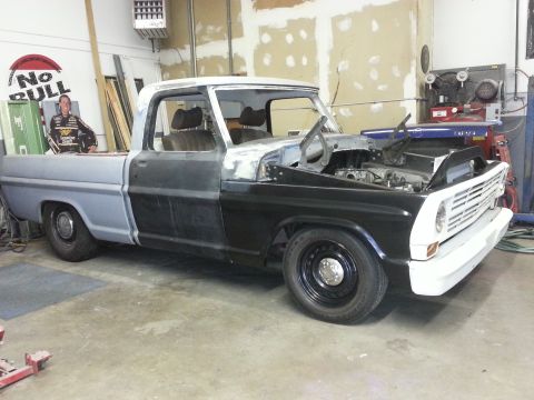 1967 Ford F-100 - This 1967 Ford F-100 pickup is in a garage, showing its bodywork progress with the hood open.