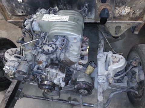 1967 Ford F-100 - Engine bay view of a 5.0 HO engine, likely from a Ford truck or car, showing the front of the engine and surrounding chassis components.