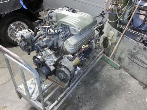 1967 Ford F-100 - Engine assembly on a metal cart in a workshop setting.